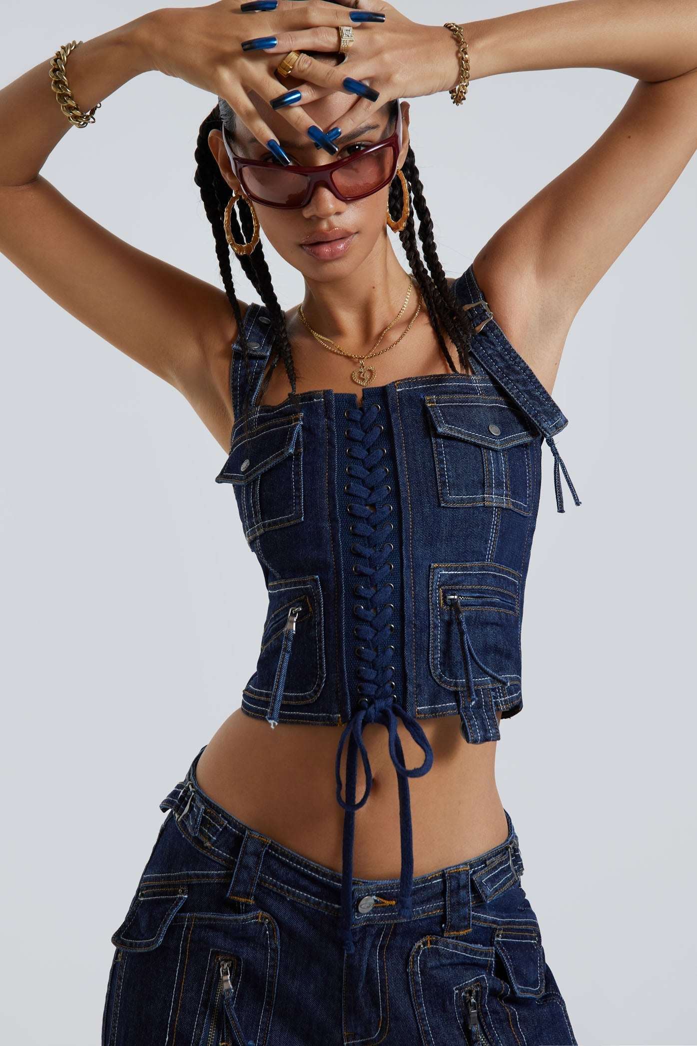 Female wearing indigo blue denim cargo style lace up corset top. Styled with the matching denim cargo trousers.  