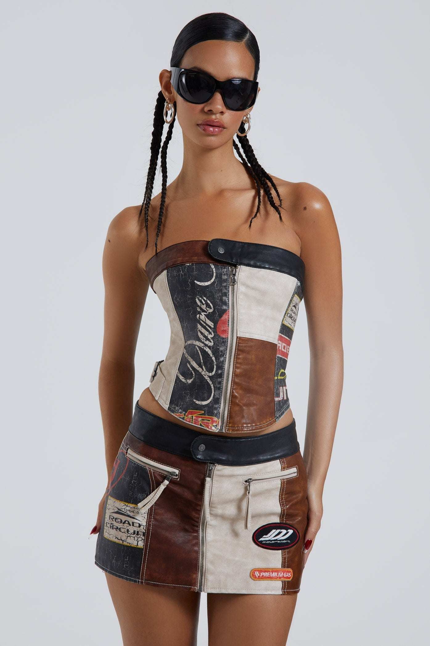 Female wearing moto PU panelled corset style bandeau top with dipped hem detail. Styled with the matching mini skirt.  