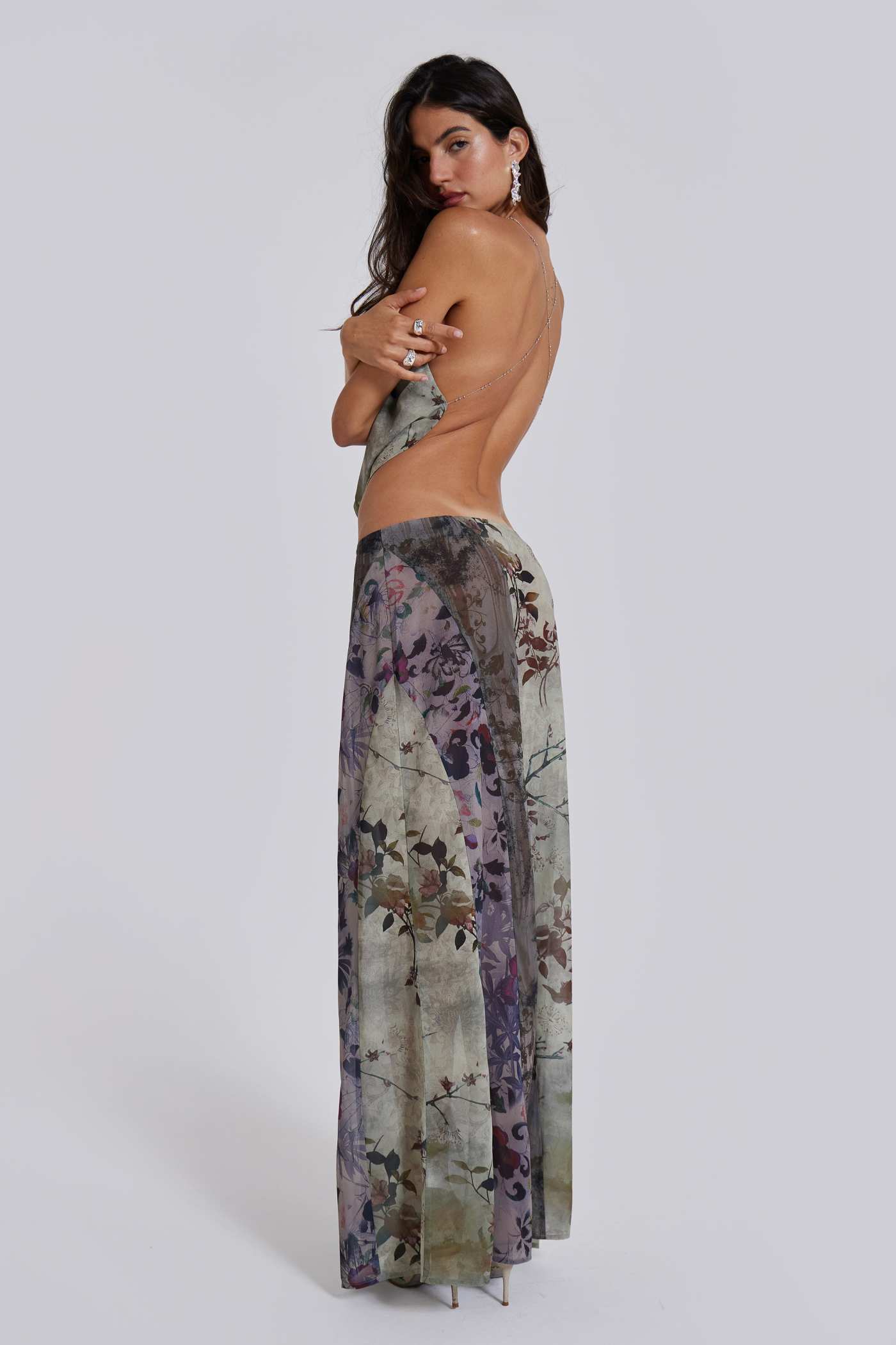 Female model wearing a floral maxi length skirt with panelled patchwork detail. Styled with the matching cowl neck top. 