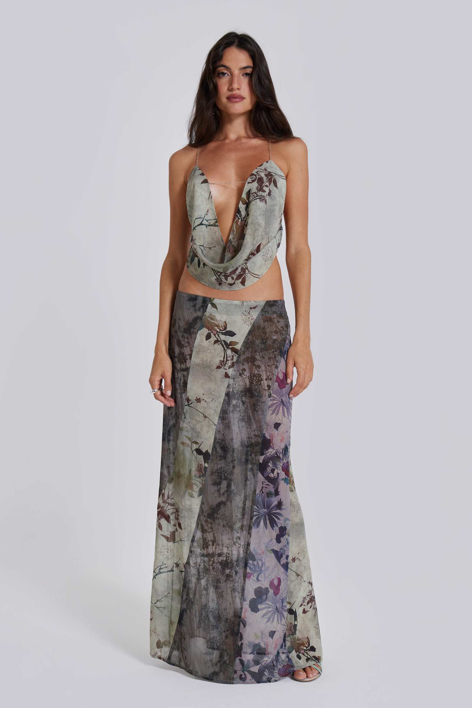Female model wearing a floral maxi length skirt with panelled patchwork detail. Styled with the matching cowl neck top. 