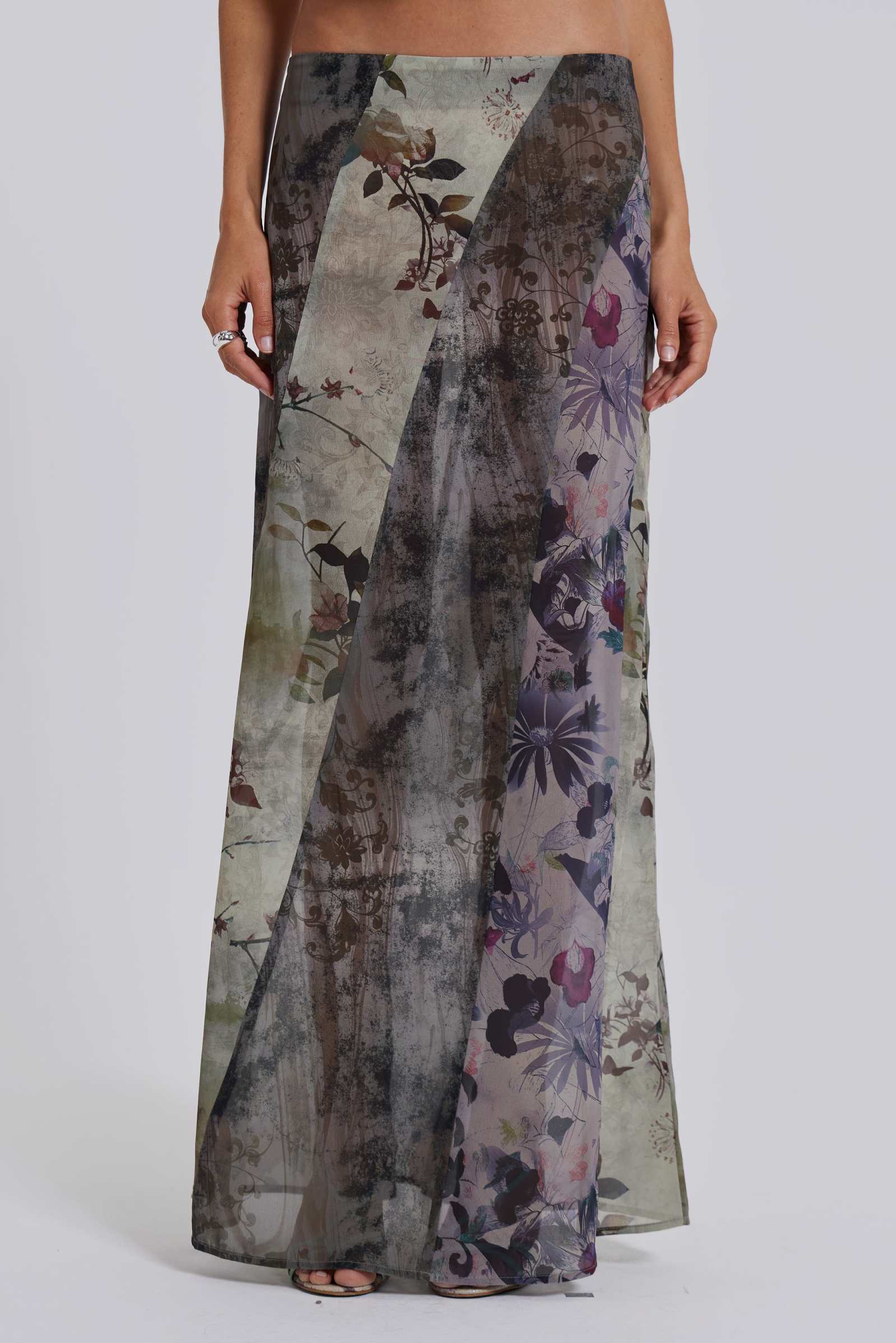 Female model wearing a floral maxi length skirt with panelled patchwork detail. Styled with the matching cowl neck top. 
