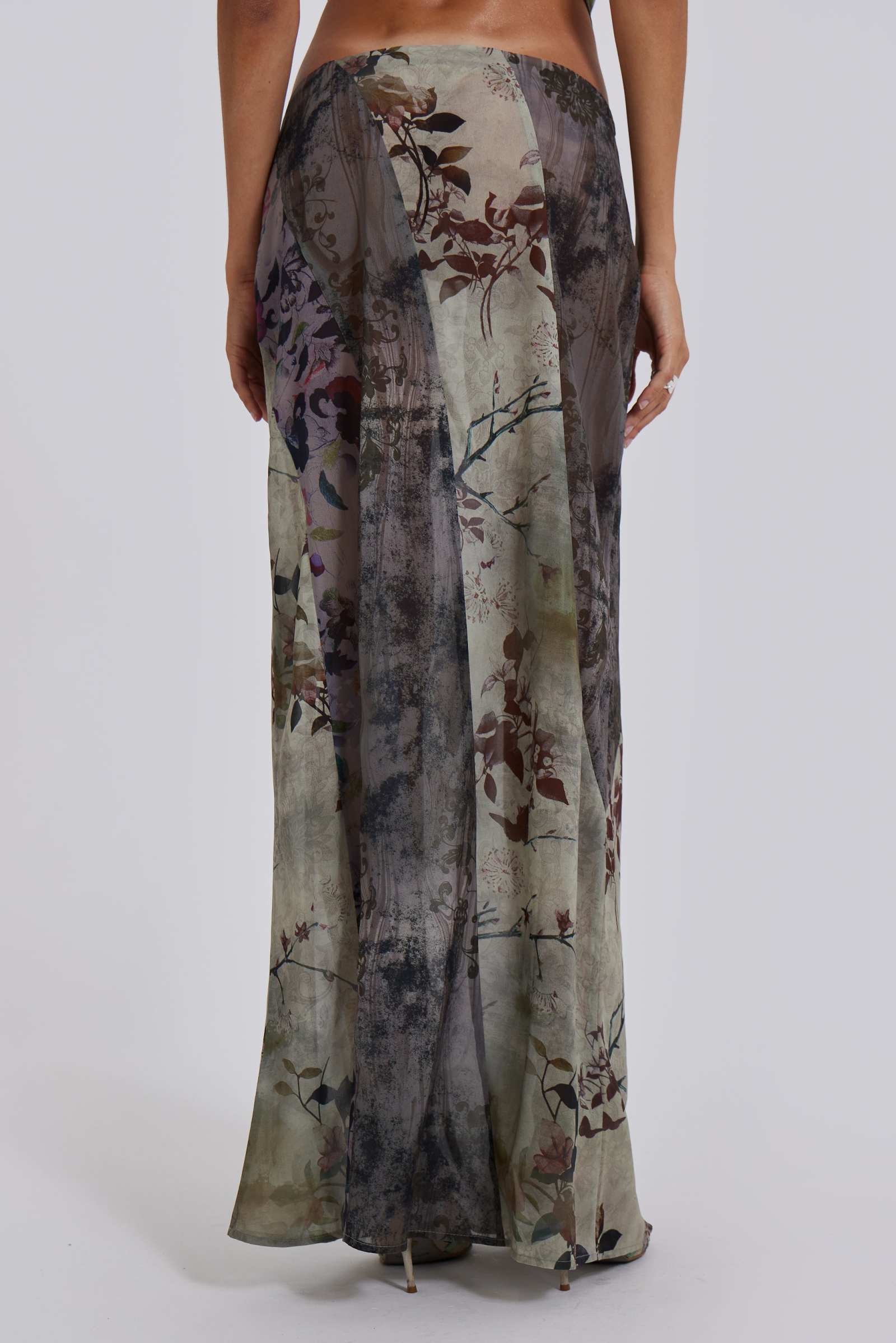 Female model wearing a floral maxi length skirt with panelled patchwork detail. Styled with the matching cowl neck top. 