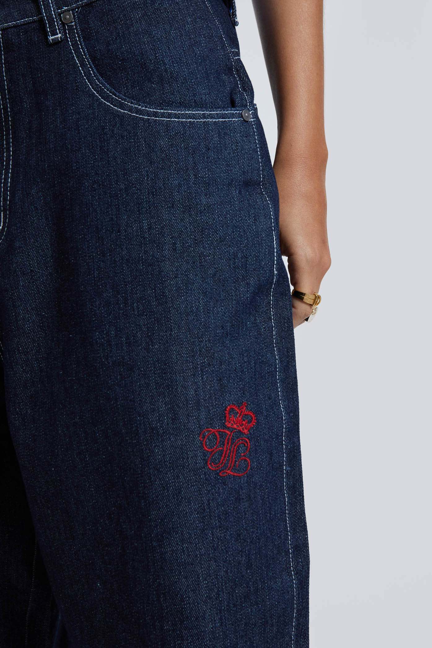 Female wearing sandblast washed denim oversized jorts in a jumbo fit with embroidered pocket patch detail. 