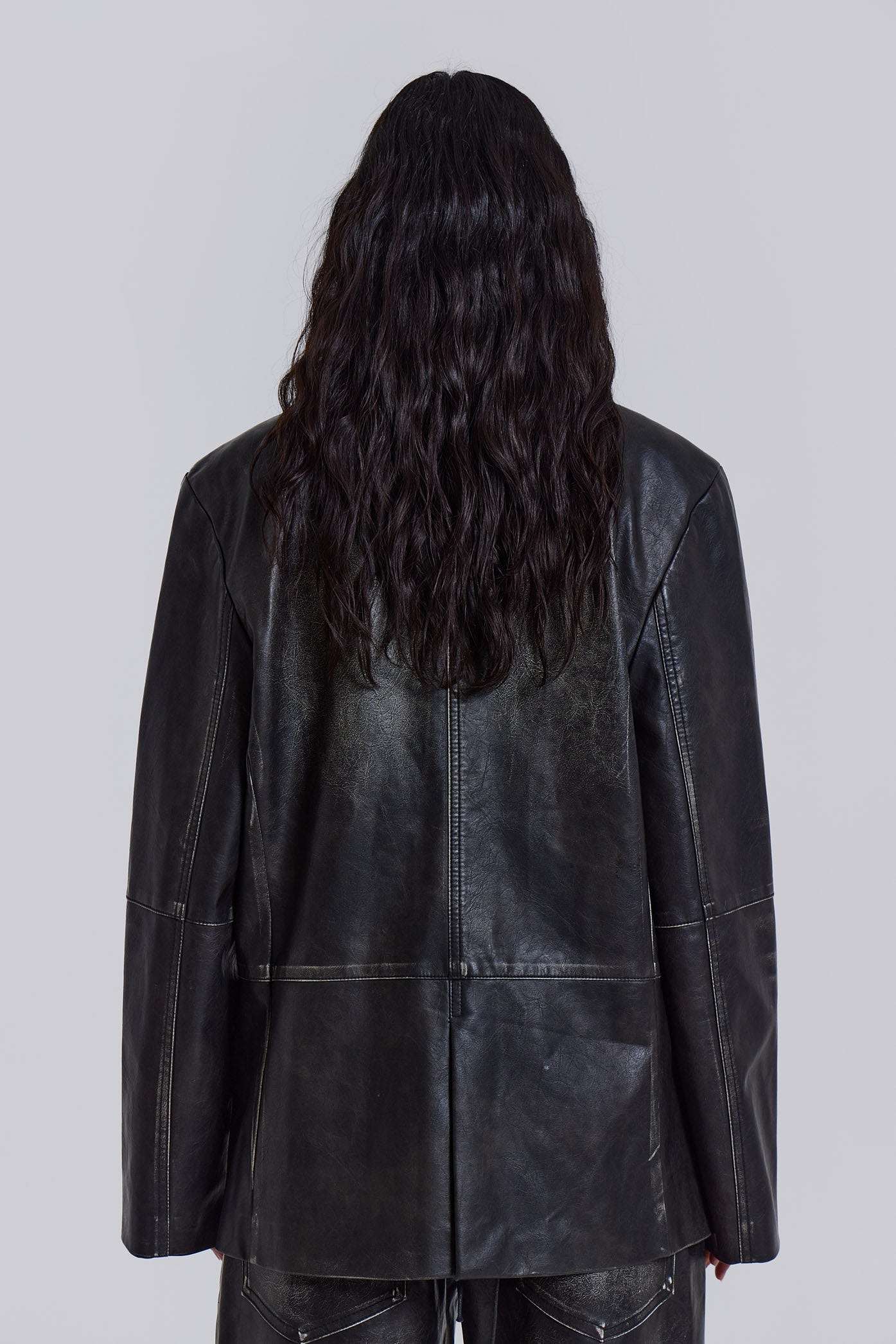 Introducing the Ash Blazer - crafted from a faux leather PU fabric with a unique heavy acid wash finish in an off-black colourway, this oversized fit blazer features a two-button front, jet pockets with flaps on the chest and a back vent, the blazer is fully lined and perfect for layering.